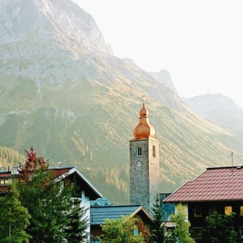Dorf mit Kirche vor einem Berg